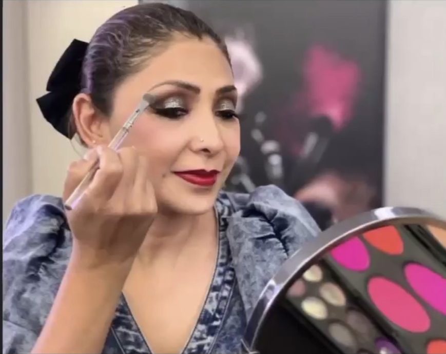 Mary aplicándose sombra junto a una paleta de colores