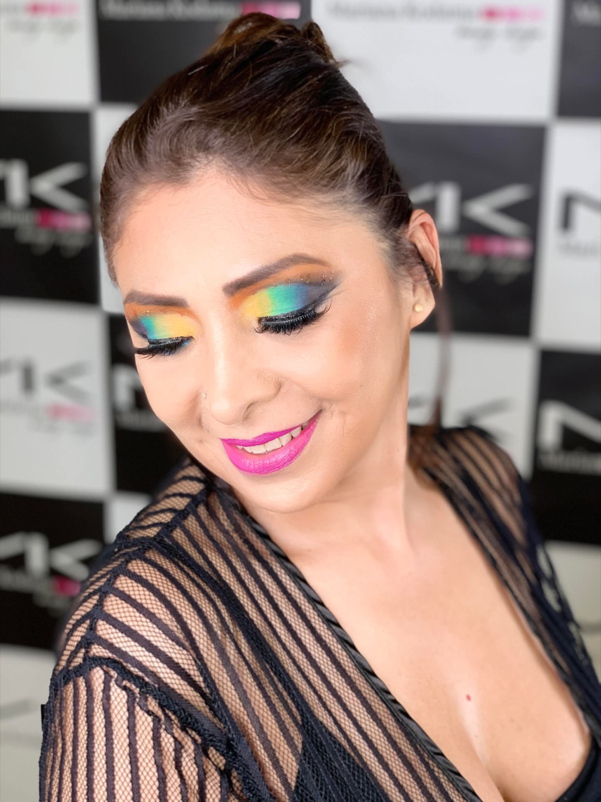 Retrato de Mary con un maquillaje de ojos en degradado de naranja, amarillo, verde y azul
